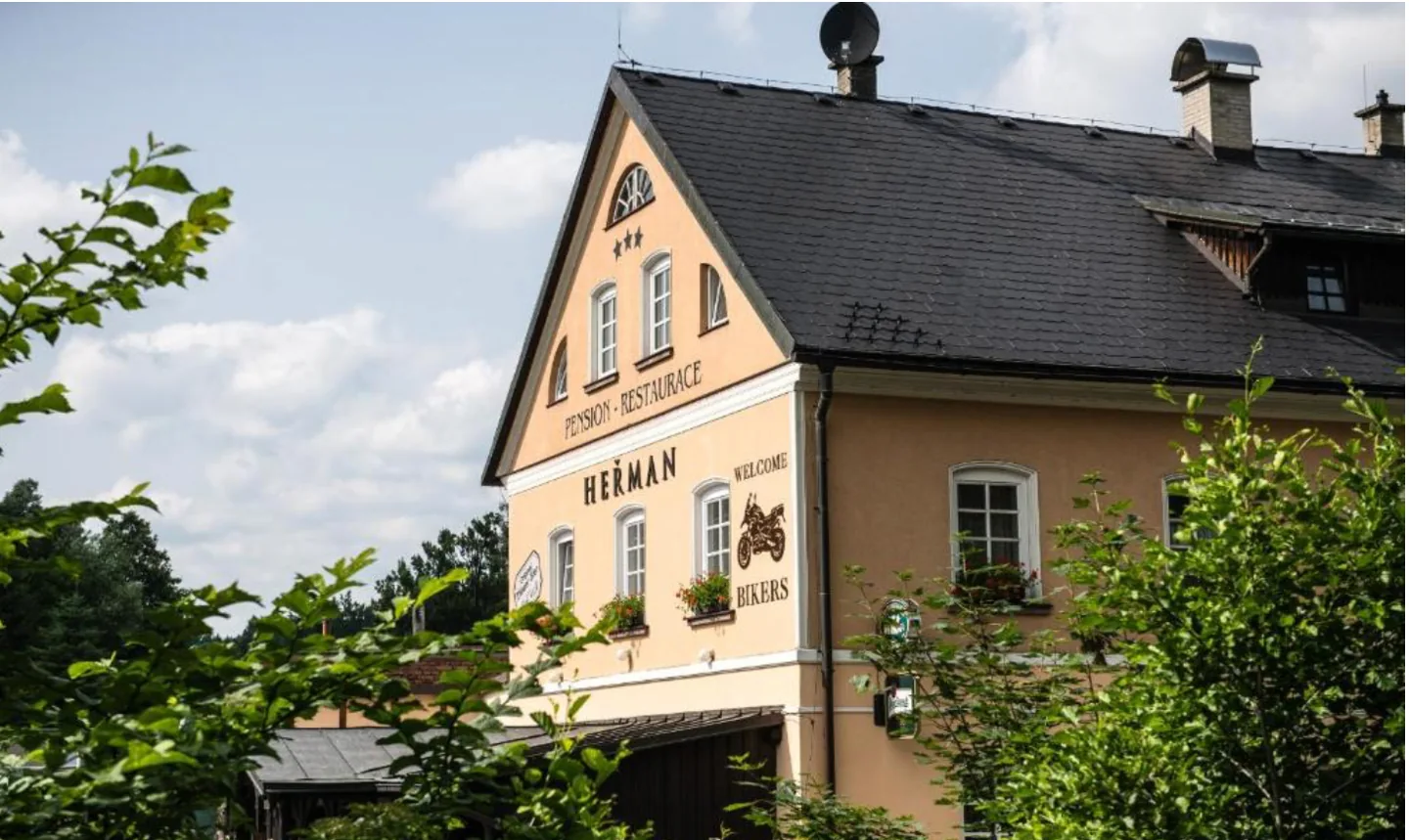 Denní pohled na Pension Heřman přes zeleň